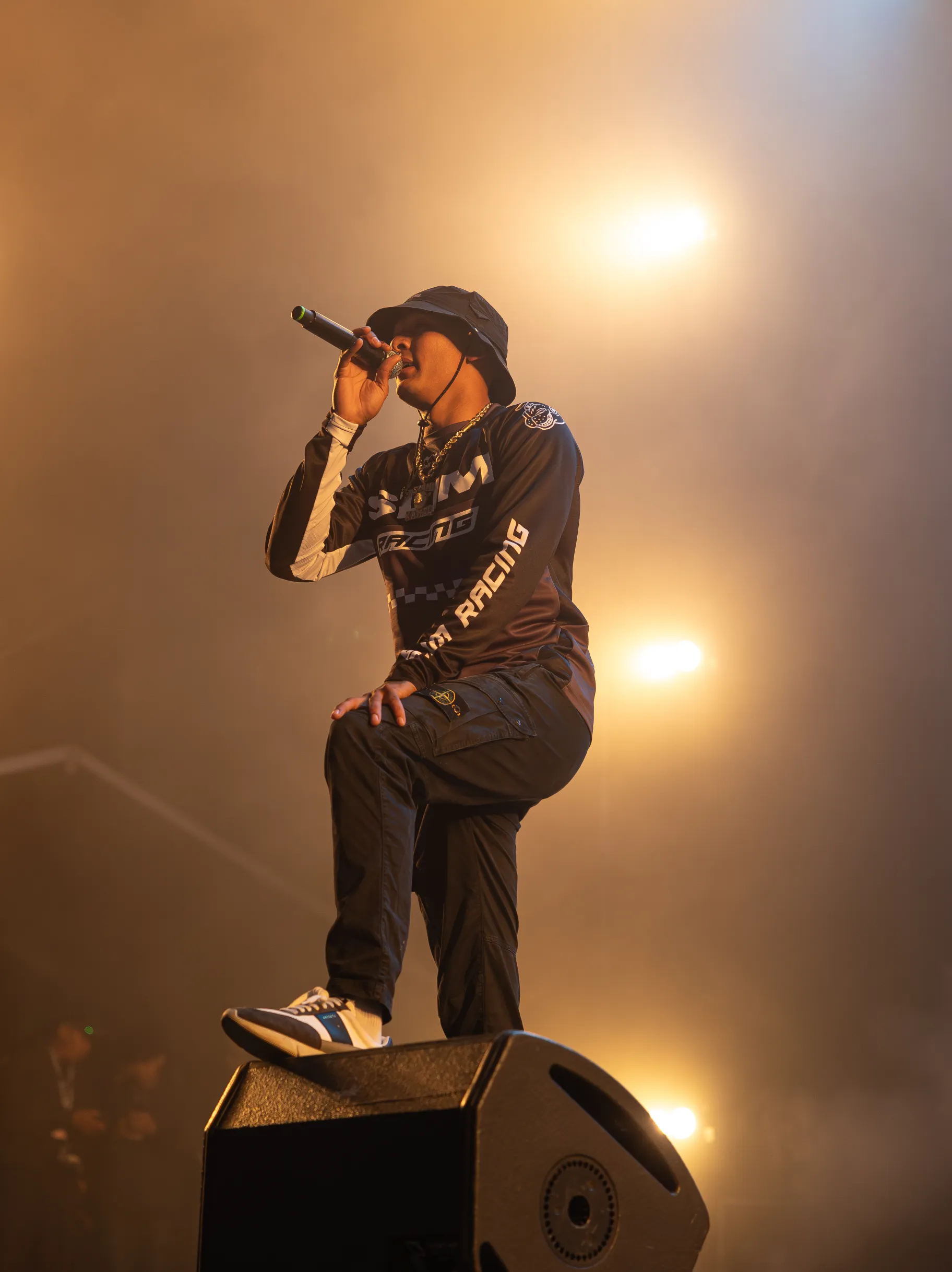 An artist stands on stage, holding a microphone